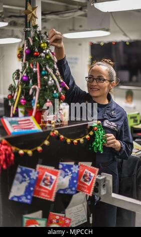 171217-N-MJ135-1061 Golfe Arabique (Dec. 17, 2017) Spécialiste des questions de personnel 1re classe Susan Figueroa décore un arbre à bord du porte-avions USS Theodore Roosevelt (CVN 71). Theodore Roosevelt et son groupe aéronaval sont déployés dans le domaine de la 5e flotte américaine des opérations à l'appui des opérations de sécurité maritime pour rassurer les alliés et les partenaires et de préserver la liberté de navigation et la libre circulation du commerce dans la région. (U.S. Photo par marine Spécialiste de la communication de masse 3 Classe Spencer Roberts/libérés) Banque D'Images