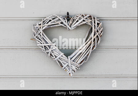 Libre d'un ornement de forme coeur gris gris sur une porte en bois. Banque D'Images