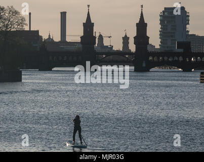 04 mai 2018, l'Allemagne, Berlin : un stand up paddler se déplace vers l'Oberbaumbruecke au coucher du soleil. Photo : Paul Zinken/dpa Banque D'Images