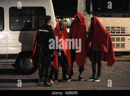 Malaga, Espagne. 6 mai, 2018. Les migrants qui a été sauvé d'un canot à la mer Méditerranée, de parler avec un agent de poilice après leur arrivée au Port de Malaga. Les membres de la sécurité maritime espagnol a sauvé en ce début de matinée, un total de 110 migrants des deux bateaux près de la côte de Malaga. Credit : Jésus Merida/SOPA Images/ZUMA/Alamy Fil Live News Banque D'Images