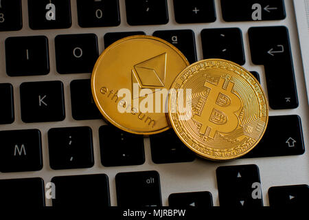 Et Bitcoin Ethereum cryptocurrency coins sur un ordinateur au clavier sur une vue de dessus Banque D'Images