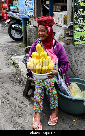 BEDUGUL, INDONÉSIE - Le 18 mars 2015 : une femme homme vend du maïs bouilli dans le populaire marché de Candi Kuning Bali's highlands Banque D'Images