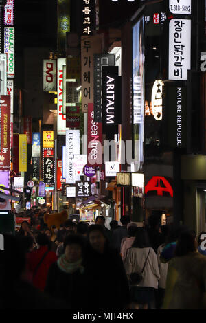 Les gens affluent à l'animation de la zone Myeongdong de Séoul, Corée du Sud, dans la soirée pour faire des achats, de l'alimentation de rue de l'échantillon, vérifier les modes, les tendances. La foule dense. Banque D'Images