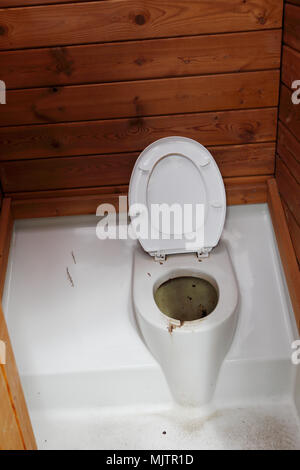 L'intérieur d'une toilette sèche avec un blanc toilettes avec un siège de toilettes surélevé Banque D'Images