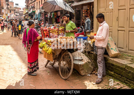 Les commerçants et les propriétaires de magasin et les clients vendre et acheter des marchandises dans les rues de Bhaktapur, Népal Banque D'Images