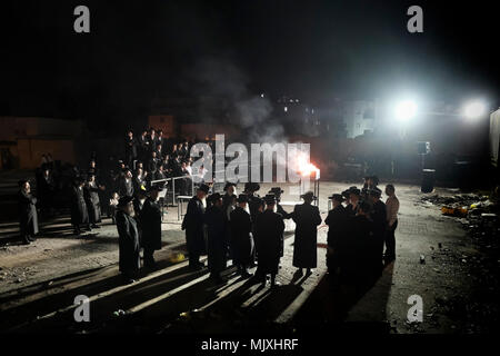 Les hommes juifs ultra-orthodoxes de la dynastie hassidique Shomrei Emounim danse comme ils allument un feu d'huile géant dans le quartier religieux Geula lors de la fête de Lag BaOmer qui marque la célébration, interprétée par certains comme l'anniversaire de la mort de Rabbi Shimon Bar Yochai, un des grands sages du judaïsme, il y a quelque 1800 ans et le jour où il a révélé les secrets de la kabbale un texte historique de la mystique juive Banque D'Images