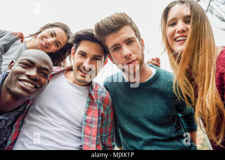 Groupe multiracial d'amis en tenant dans un parc urbain selfies Banque D'Images