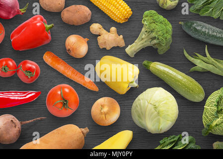 Colorées, rouge, orange, jaune et vert légumes sur surface noire. Banque D'Images