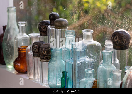 Sélection Aa ou collection de vieux meubles poussiéreux de chimistes et de bouteille d'apothicaire couvert de poussière sur une étagère. Couleur vieux bouteilles et bocaux en verre vintage Banque D'Images