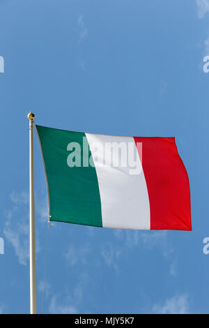 Le drapeau national de l'Italie au ciel bleu. Banque D'Images