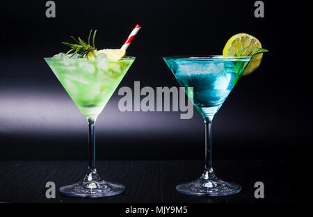 Cocktails d'été colorés dans les verres sur fond noir Banque D'Images