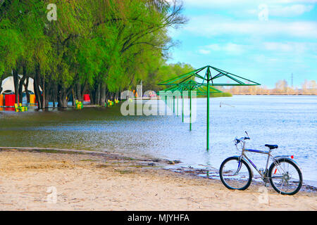 Lonely location standing on beach pendant les inondations sur plage de la ville. Plage vide auvents inondé avec de l'eau en période de crue au printemps et en vélo. Wa Haut Banque D'Images