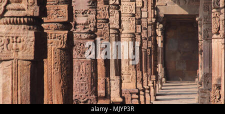 Colonnes en pierre sculptée au 12ème siècle Quwwat-ul-Islam mosquée de Delhi, Inde Banque D'Images