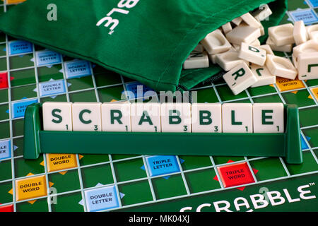 Tambov, Fédération de Russie - Mai 02, 2018 Jeu de Scrabble. Mot de Scrabble lettre carreaux carreaux en rack sur terrain avec cordon lettre sac. Banque D'Images