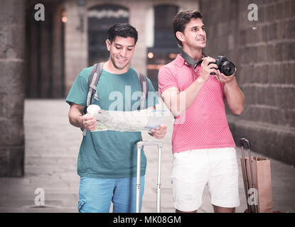 Portrait de deux hommes qui marchent avec la carte et la photographie dans la rue à Barcelone. Banque D'Images