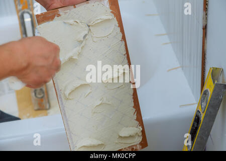 Mason Construction man mains sur travail carreaux au mortier de ciment Banque D'Images