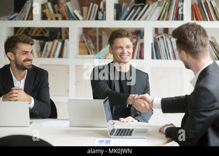 Chef de l'accueil de nouveaux collègue masculin alors que la négociation in office Banque D'Images