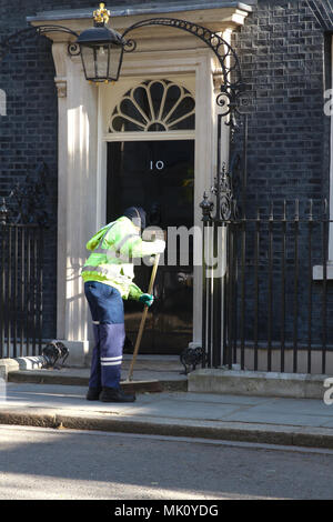 Un nettoyeur de rue balaie l'extérieur numéro 10 Downing Street à Londres, accueil de Theresa May, Premier Ministre du Royaume-Uni Banque D'Images