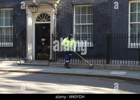 Un nettoyeur de rue balaie l'extérieur numéro 10 Downing Street à Londres, accueil de Theresa May, Premier Ministre du Royaume-Uni Banque D'Images