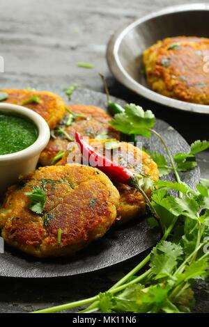 Aloo Tikki / snack indien Galettes de pommes de terre servis avec un chutney de coriandre Banque D'Images