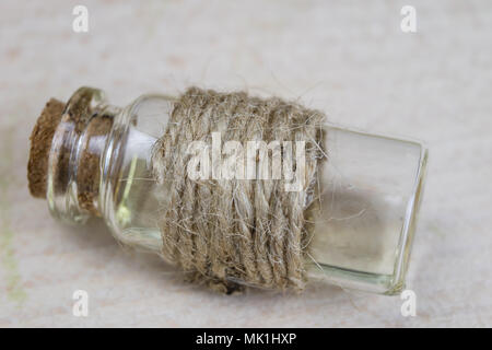 Sirop de guérison au cours de la grippe. La spécificité des ingrédients médicinaux dans une petite bouteille. Fond clair. Banque D'Images