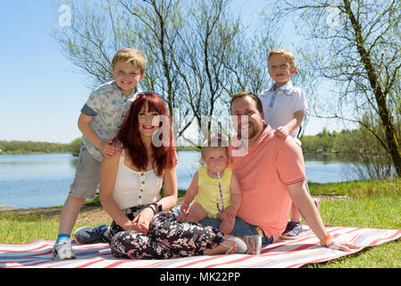 La mère, le père de famille avec deux fils et la fille par un par un après-midi ensoleillé au bord du lac Banque D'Images