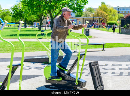 Un homme âgé s'exercer sur un parc machine marche Banque D'Images