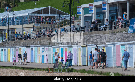 Soleil à Lyme Regis, dans le Dorset, UK. 6 mai 2018. Météo France : Les Visiteurs depuis la promenade des cabines de plage sur Marine Parade comme la côte sud resort ville de Lyme Regis accueille chaque année le Festival de fossiles sous le ciel bleu et le soleil chaud sur la banque mai week-end de vacances. Credit : PQ/Alamy Live News Banque D'Images