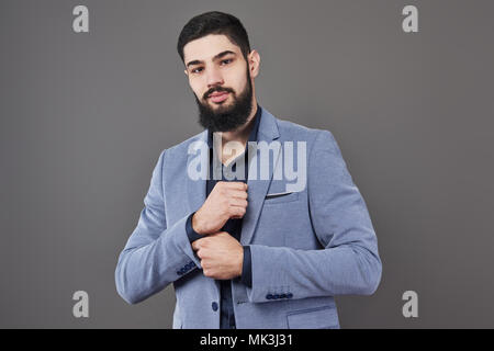 Portrait de freelancer homme avec barbe veste en toile gris contre permanent Banque D'Images