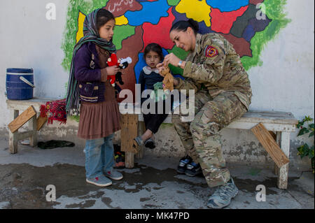 L'Adjudant-chef 3 Harrington Milfie, opérations spéciales de l'Armée nationale afghane, mentor du groupe consultatif aide à la routine des commandos afghans articles essentiels distribution à la Camp Commando clinique médicale, Kaboul, le 6 novembre 2017. Tous les éléments fournis à la femme afghane et les enfants sont donnés dans les villages locaux. Banque D'Images