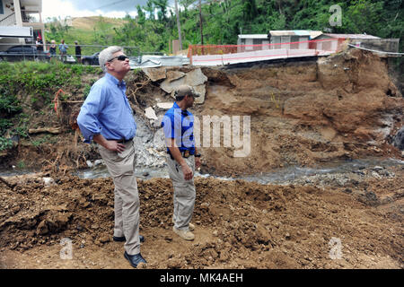 Arecibo, Puerto Rico - Sen. Bill Cassidy (R-LA) (gauche) observe un quartier dans la région montagneuse de Arecibo municipalité, le 6 novembre, isolée en raison d'un pont emporté et durement touchées par les glissements de terrain au cours de l'Ouragan Maria. Cassidy, avec d'autres membres du Sénat et de la Chambre, a effectué une visite de deux jours aux îles Vierges américaines et Porto Rico pour voir de première main les zones touchées par la tempête et les efforts de secours. Banque D'Images