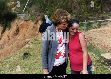 Arecibo, Puerto Rico - La sénatrice Lisa Murkowski (R-AK) résident Tania Matias confort Arecibo Guzman lors d'une délégation du congrès américain visite dans cette petite municipalité de montagne le 6 novembre. À sept mois de grossesse, Guzman n'a pas eu accès direct à son domicile depuis l'Ouragan Maria frappé Porto Rico le 20 septembre. L'allée de Guzman's home peut être vue dans le contexte de la photo, de l'autre côté d'un glissement de terrain qui a enlevé une grande partie de l'autoroute. Banque D'Images