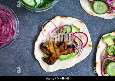 Tortillas vegan avec champignons, avocat, oignons marinés et concombre Banque D'Images