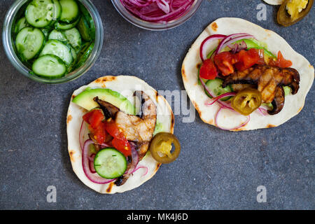 Tortillas vegan avec champignons, avocat, oignons marinés et concombre Banque D'Images