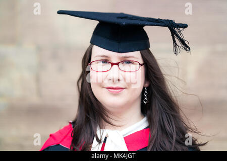 Plus-Size mature Female Graduate Wearing Cap & robe longue avec des lunettes Banque D'Images