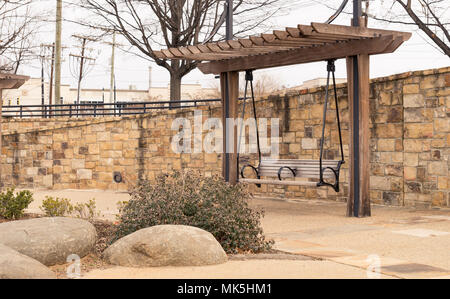 Pergola banc en pierre à côté du parc sur mur de brique allée de gravier Banque D'Images