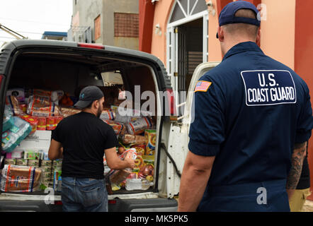 U.S. Coast Guard Maître de 1re classe Austin Nouveau venu aide un groupe missionnaire local comme ils livrer des fournitures aux sections locales dans la région de Loiza, Porto Rico, le 8 novembre 2017. Près de 15 000 personnels civils et militaires du gouvernement fédéral les membres du service, dont plus de 2 000 membres du personnel de la FEMA, sont sur le terrain à Porto Rico et les Îles Vierges américaines engagées dans l'intervention et le rétablissement de la paix par les ouragans Maria et de l'Irma. U.S. Coast Guard photo de Maître de 2e classe Ali Flockerzi. Banque D'Images