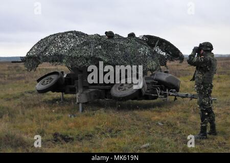 Soldat roumain affecté à la défense aérienne de la base de la masse de l'Armée de "détachement", la Chauve-souris noire sert un chef d'équipe, observe le terrain avant de lancer la commande d'incendie à l'équipe du canon canon à tir réel d'un Wierzbiny au domaine de formation, la Pologne le 14 novembre 2017. Banque D'Images