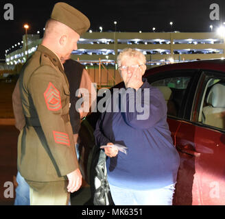 Sandra Lewis, la nièce du Marine Corps Pvt. Vernon Paul Keaton, lingettes larmes après avoir parlé avec le sergent d'artillerie. Nicholas Brundige, sous-Marine Corps directeur de funérailles, siège de Marine Barracks, à Washington, D.C., dans une section isolée de l'Aéroport Will Rogers World le 14 novembre 2017, à Oklahoma City, Oklahoma. Lewis est le plus proche parent encore vivant de Keaton qui a été tué le 7 décembre 1941, au cours de l'attaque japonaise sur Pearl Harbor, Hawaii. Keaton ses restes ont récemment identifié positivement par le ministère de la Défense à l'internement et le sergent d'artillerie. Brundige escorté les vestiges d'Oklahom Banque D'Images