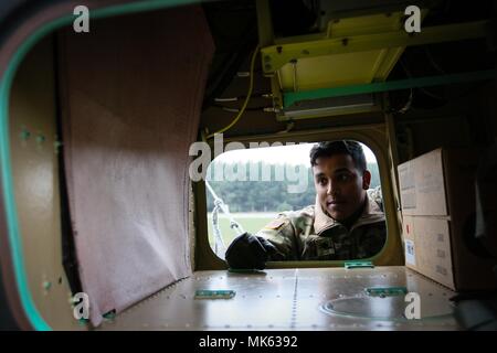 La CPS. Maurizio Walker, un Virginia Beach, en Virginie et native de réparateur d'hélicoptère d'attaque AH-64 avec le 227e Régiment d'aviation, 1st Air Cavalry Brigade, Division de cavalerie, inspecte un hélicoptère Apache AH-64 après qu'il a été volé à Powidz, Pologne, le 10 novembre 2017 à l'appui de la résolution de l'Atlantique. Résoudre l'Atlantique est une entreprise américaine de s'acquitter des engagements de l'OTAN par rotation des unités dans l'ensemble du théâtre européen à prévenir les agressions contre les alliés de l'OTAN en Europe. (U.S. Photo de l'armée par la CPS. Hubert D. Delany III/22e Détachement des affaires publiques mobiles) Banque D'Images