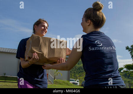 LOS LLANOS, Puerto Rico - Paige Landers, un étudiant de la Liberty University, à Lynchburg, Virginie passe une boîte d'épicerie aux Kristen Busby, un autre étudiant avec la Liberty University, dans une église locale, le 14 novembre 2017. Les étudiants sont des bénévoles avec Samaritan's Purse, ce qui a aidé l'Agence fédérale de gestion des urgences, l'armée, et des bénévoles de l'épicerie pour distribuer 1 000 familles dans la région. (U.S. Photo de l'armée par le Sgt. Avery Cunningham) Banque D'Images