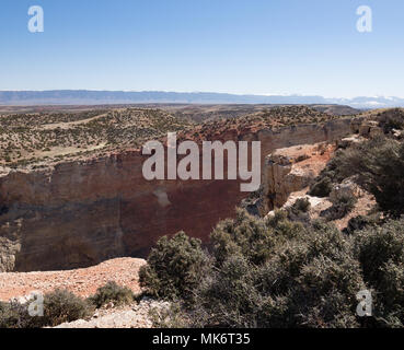 Les parois du canyon coloré de Bighorn Canyon National Recreation Area avec végétation en premier plan et ciel bleu au-dessus. Banque D'Images