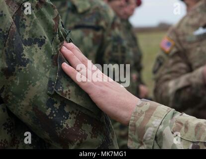 Un parachutiste affecté à la 173e Brigade aéroportée trades sur les épaules avec un parachutiste des Forces armées serbes sur Lisicji Aéroport Jarak, la Serbie, le 17 novembre 2017. Les parachutistes américains et serbes dans l'ensemble des exercices effectués au cours de l'effort d'insertion Double Eagle à apprendre les uns des autres et d'établir des relations à promouvoir la sécurité régionale. (U.S. Photo de l'Armée de l'air par la Haute Airman Elizabeth Baker) Banque D'Images