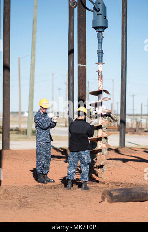 KyleChristenson apprenti marins et Samantha Tovar, 366 étudiants, sont Sqadron de formation de la vis de guidage lame pour creuser un trou pendant la classe à Sheppard Air Force Base, Texas, le 20 novembre. Le trou est creusé pour mettre un poteau de 30 pieds dans le sol pour soutenir les lignes à haute tension. (U.S. Air Force photo par Alan R. Quevy) Banque D'Images