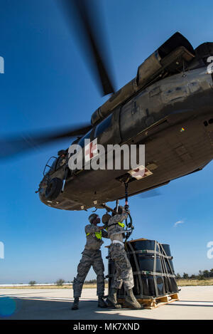 Les aviateurs de l'Antenne du 26 Escadron Port attacher un A-22 cargo sac avec 2 000 livres de "secours" pour le crochet de charge d'un UH-60 Black Hawk pilotés par des soldats de la Garde nationale du Texas de l'entreprise C, 2-149 pendant le fonctionnement de l'aviation d'évacuation d'Alamo Le 18 novembre 2017, à l'aérodrome de l'Armée de Martindale, Texas. 36 000 livres de fret et 27 passagers ont été transportés dans le cadre de la charge sous élingue et exercice d'évacuation médicale. (U.S. Photo de l'Armée de l'air par la Haute Airman Stormy Archer) Banque D'Images