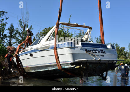 L'équipe de plongée de sauvetage locaux et réglage personnel de sangles autour du bateau de plaisance de 38 pieds Spook'n Me le 22 novembre, 2017 à Ponce, Porto Rico, après avoir lavé à terre lorsque l'Ouragan Maria frappa l'île. La FSE Maria-10 PR Commandement unifié, composé du Ministère des Ressources naturelles et environnementales, la Garde côtière, en collaboration avec le Porto Rico la qualité de l'environnement, de contrôle de l'Environmental Protection Agency et le U.S. Fish & Wildlife Service et, répond aux navires endommagés, déplacées, immergé ou déprimées. Photo de la Garde côtière des États-Unis par l'officier marinier 2 Banque D'Images