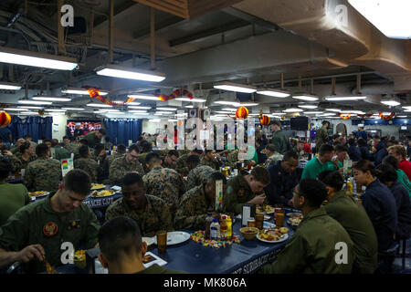 Les Marines américains et les marins mangent pendant le dîner de Thanksgiving à bord du navire d'assaut amphibie Iwo Jima (DG 7), dans l'Océan Atlantique le 23 novembre 2017. Les Marines et les marins du 26e Marine Expeditionary Unit (MEU) a pris une pause de l'unité de formation composite combinée (Exercice COMPTUEX) opérations pour fêter Thanksgiving avec un souper à la dinde traditionnelle. (U.S. Marine Corps photo par le Cpl. Jon Sosner) Banque D'Images