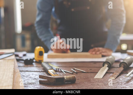 Sur l'équipement de bureau en bois avec l'homme travaillant en atelier. Banque D'Images