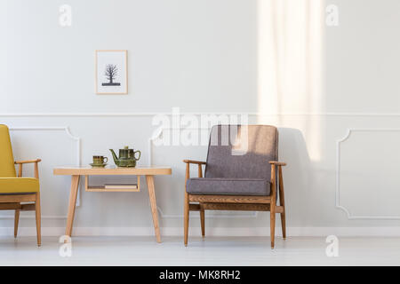 Fauteuil en bois gris à côté du tableau de la salle de séjour minimal intérieur avec baldaquin blanc sur mur de moulage Banque D'Images