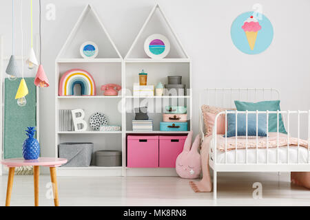 Les lampes colorées au-dessus de table dans la chambre de l'enfant populaire avec de la crème glacée de l'intérieur lit ci-dessus de l'affiche Banque D'Images